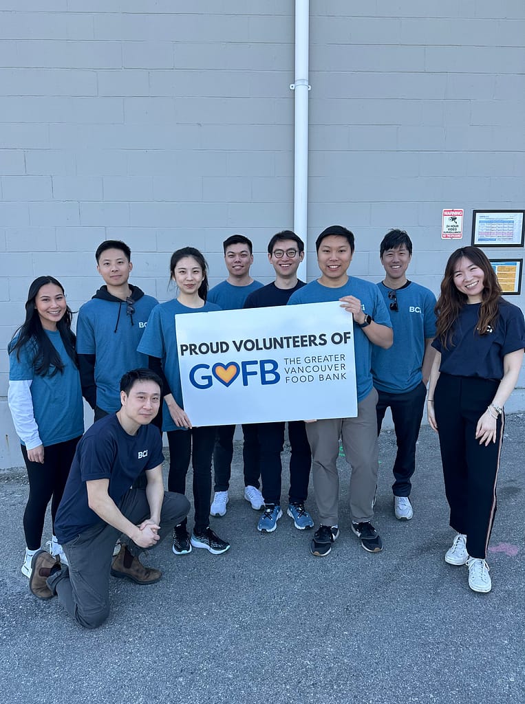 Group of people posing with a banner that reads: 'PROUD VOLUNTEERS OF GVFB THE GREATER VANCOUVER FOOD BANK.'