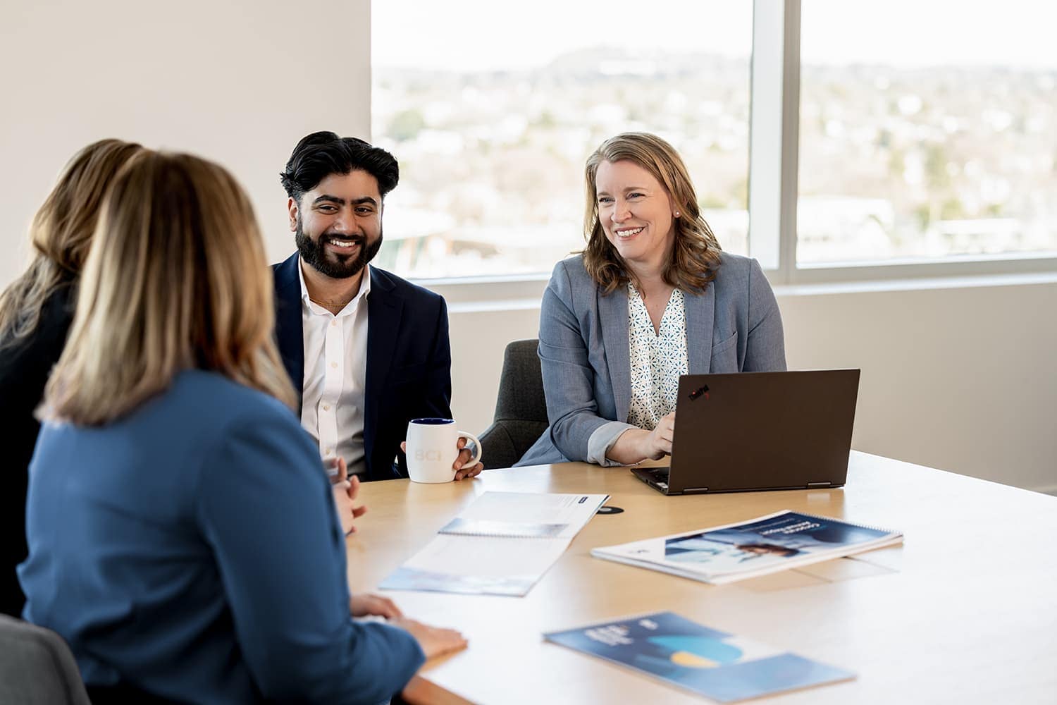 Four people collaborating at a conference table in an office building Four people collaborating at a conference table in an office building