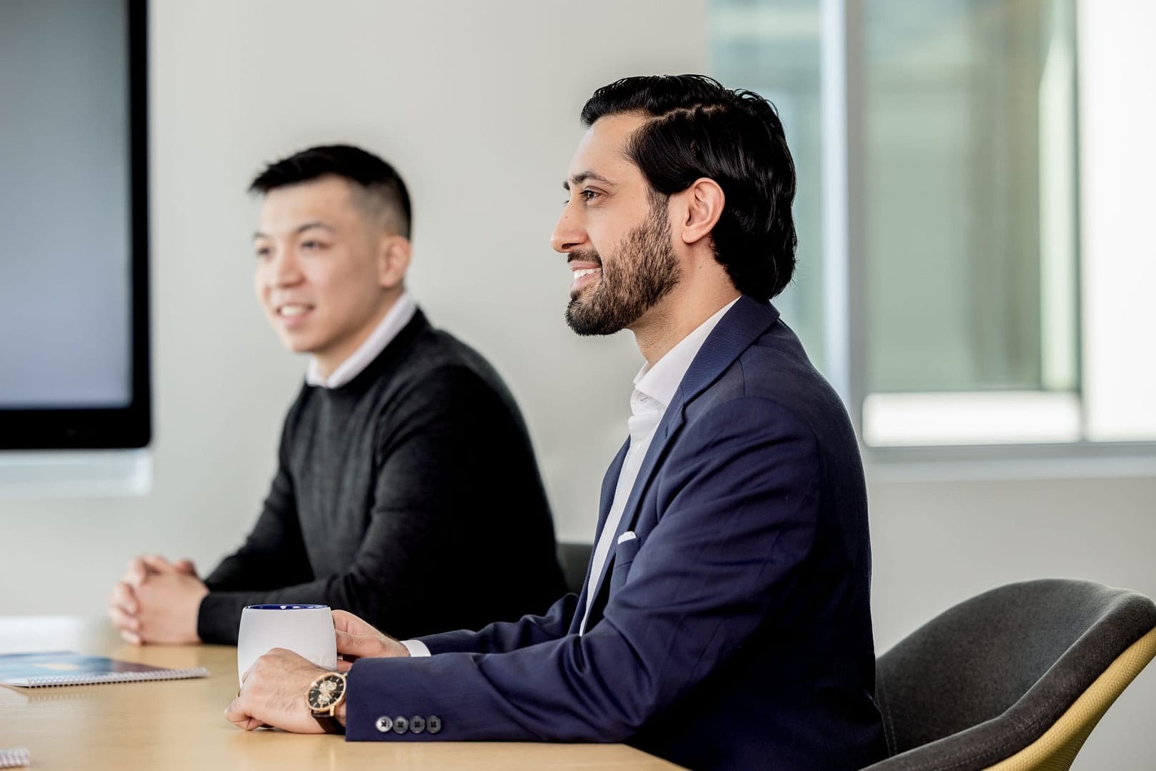 Two people smiling at conference table Two people smiling at conference table