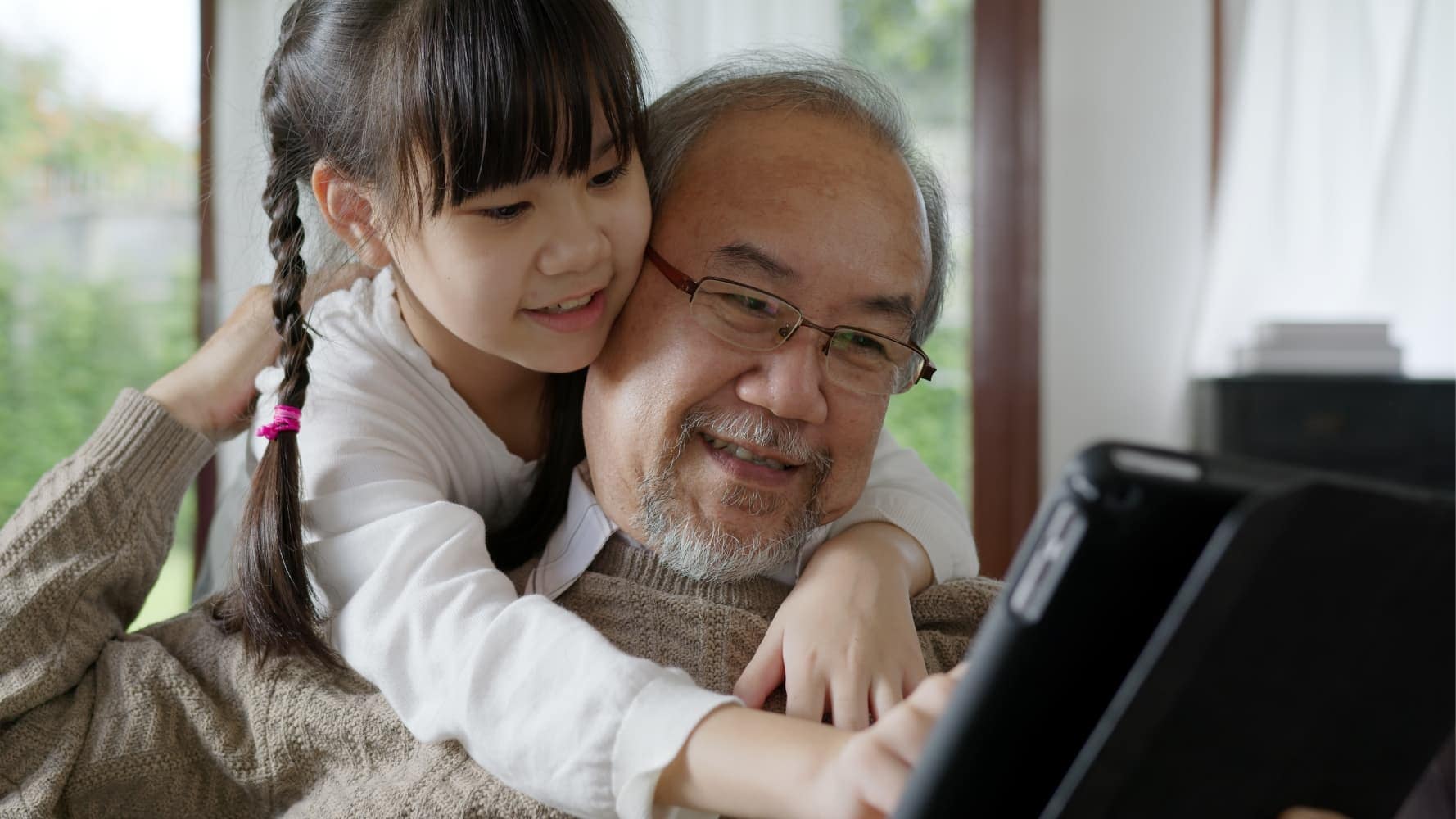 A grandfather with granddaughter using an ipad A grandfather with granddaughter using an ipad