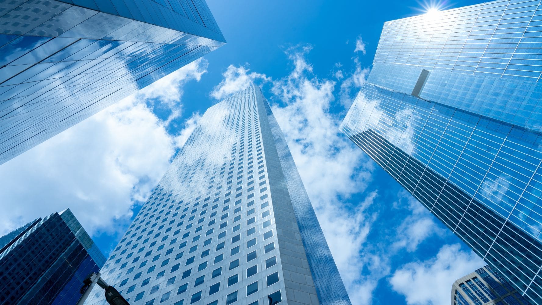 Tall glass skyscrapers against a bright blue sky with clouds Tall glass skyscrapers against a bright blue sky with clouds