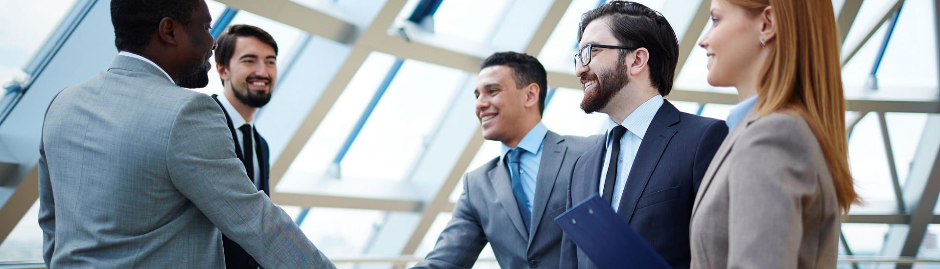 Group of people in business attire meeting and shaking hands Group of people in business attire meeting and shaking hands