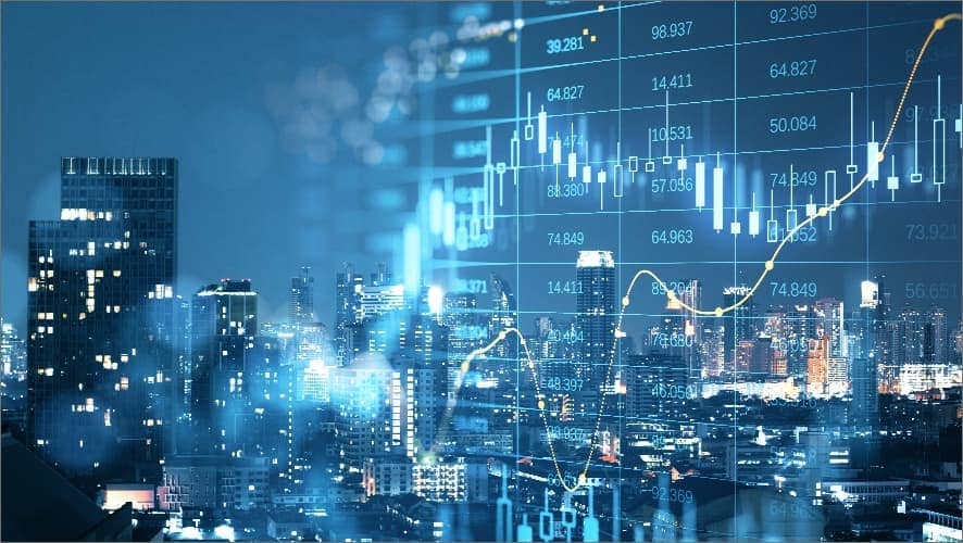 Stock market chart overlaid on city at nighttime Stock market chart overlaid on city at nighttime