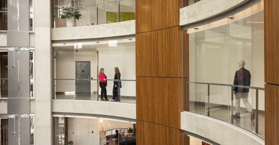 Interior of modern building with people walking in the hallways Interior of modern building with people walking in the hallways