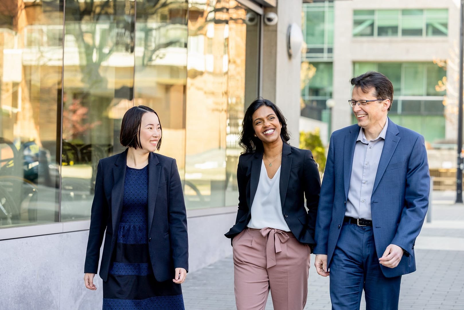 Three people walking outside smiling Three people walking outside smiling