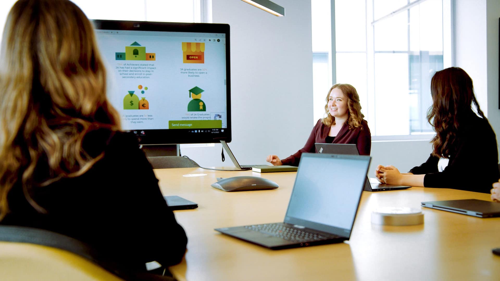 Person presenting deck to two colleagues in conference room Person presenting deck to two colleagues in conference room