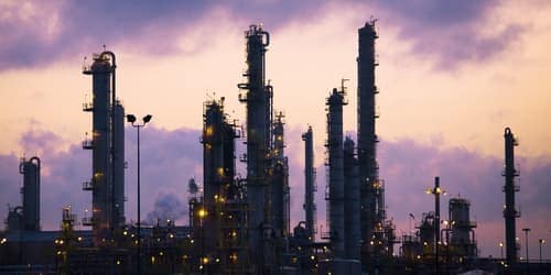 silhouette of oil drilling machines against purple sky silhouette of oil drilling machines against purple sky