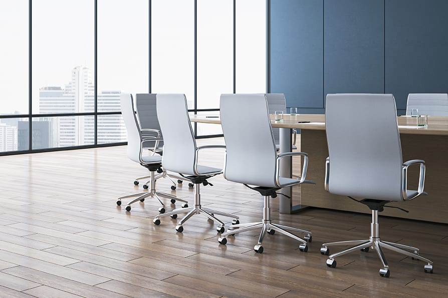 Modern conference room with city view, wooden table, and office chairs.